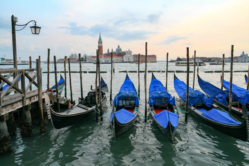 Fototapeta na wymiar Gondolas in Venice - sunset with San Giorgio Maggiore church.