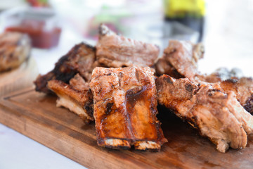 Delicious juicy ribs on wooden board