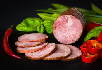 Smoked sausage with lettuce and tomatoes on wooden board