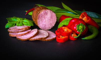 Smoked sausage with lettuce and tomatoes on wooden board