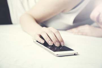 Fototapeta premium Woman sleeping in bed and holding a mobile phone