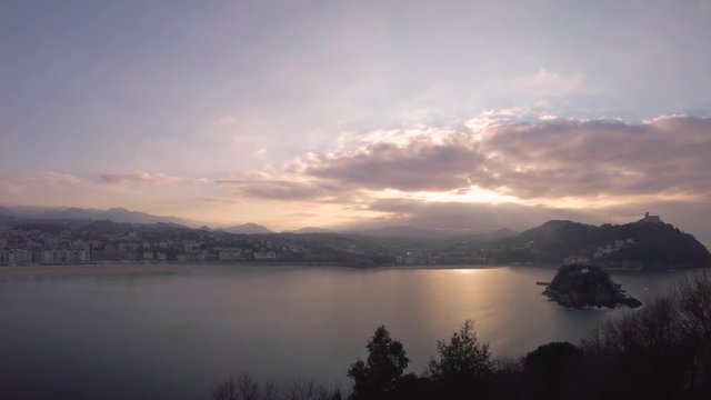 Time lapse footage of romantic sunset over San Sebastian skyline, bay and ocean.