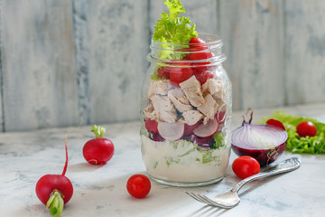 Salad with chicken and fresh vegetables in jar.