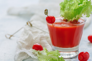 Tomato juice with ice cubes and a leaf of lettuce.