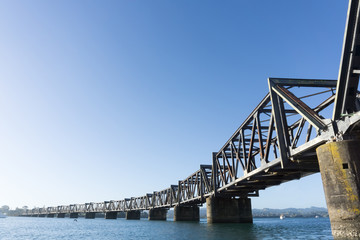 Obraz premium Tauranga harbour with steel railway bridge crossing