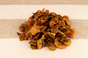 Dry apple slices, stacked on a striped fabric of flax.