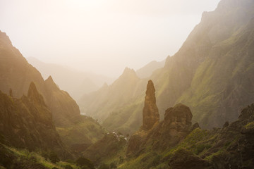 Obraz na płótnie Canvas Mountain silhouette of picturesque canyon Ribeira da Torre covered with sand dust brought from Sahara. Sugarcane, coffee and other cultivation grow on steep terraced hills. Santo Antao Cape Verde