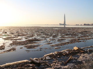 Fototapeta premium Spring in the city on the shore of the bay drift ice on the river