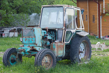 Old rusty soviet-made tractor in the farmyard. Transport