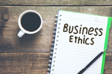 business ethics text on notepad with coffee on table