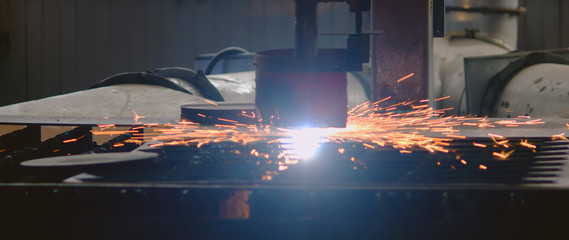 Plasma cutting machine of metal in the process of work with departing bright sparks