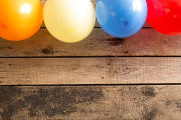 Colorful balloons on wooden table.  Copy space. 