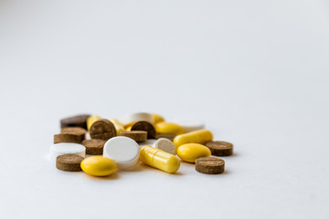 many multicolored pills and capsules on white background