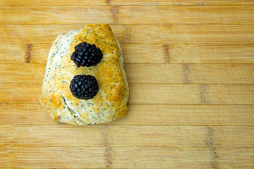 Blackberries on scone - blurred wooden table in background 
