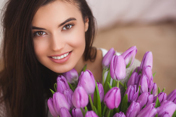 Beautiful woman with flowers indoors