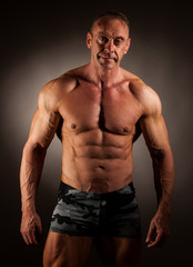 Fototapeta na wymiar bodybuilder pose in studio over dark background