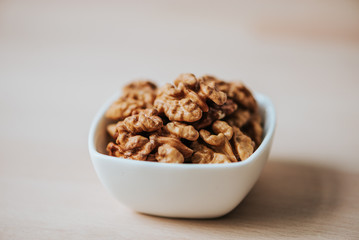 Close-up image of white bowl with walnuts.