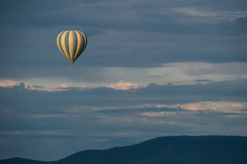 Hot air balloon over savanna hills