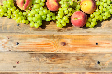 First fruits habikkurim in hebrew on wooden rustic table. Symbols of jewish holiday - Shavuot. Grapes and peaches on wood vintage background.