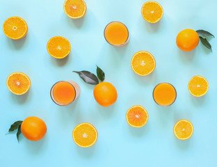 Fresh juices and fruit cut into slices on a turquoise background