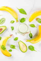 Healthy smoothie with banana and baby spinach, n white marble background copy space top view