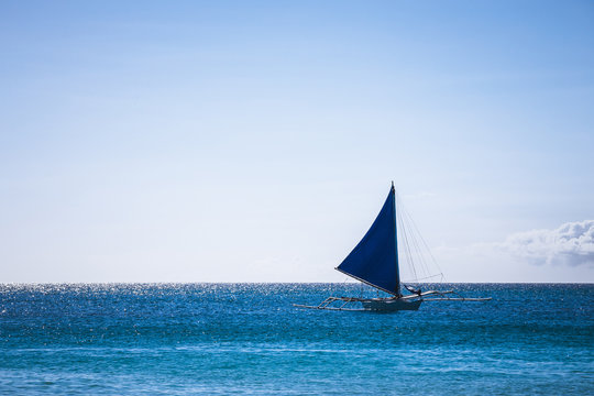 One double outrigger sailboat on the sea
