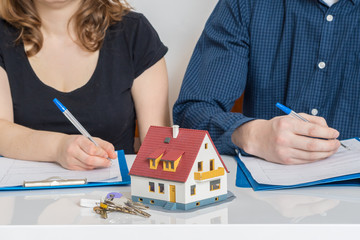 Divorce and dividing a property concept. Man and woman are signing divorce agreement. - obrazy, fototapety, plakaty