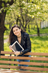 Young girl in the park with a tablet in hand.