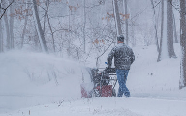 A man is removing snow using snowblower