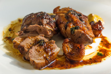 Fried duck breast with lemon sauce on a white plate close-up - natural light
