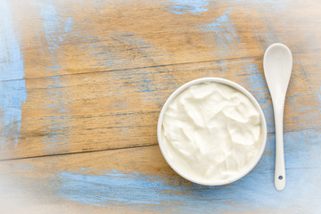bowl of Greek yogurt on grunge wood