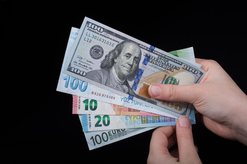 Hand holding American dollar  isolated on black background