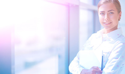 Business woman standing in foreground in office . Business woman