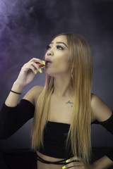 Obraz premium Young woman smoking electric cigarette