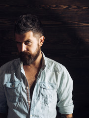 Fashion and male beauty of graying man. Haircut of bearded man, archaism. Man with beard and mustache on wooden background. Barber and hairdresser salon. Serious hipster in barbershop, look.