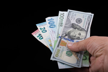 Hand holding American dollar  isolated on black background
