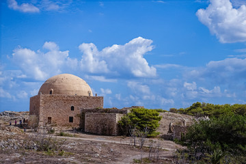 sunny summer day, a large rocky area with some historic buildings; building with a round dome; wonderful blue sky with clouds