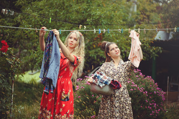 young women hanging clothes after washing in the courtyard in the open air, female life and fun