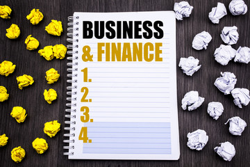 Conceptual hand writing text caption showing Business And Finance. Business concept for Company Strategy Written on notepad note notebook book wooden background with sticky folded yellow and white