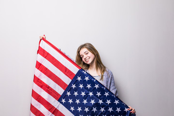 Teenage girl and American flag on gray background