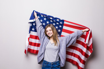 Student girl holding an american flag isolated on gray background