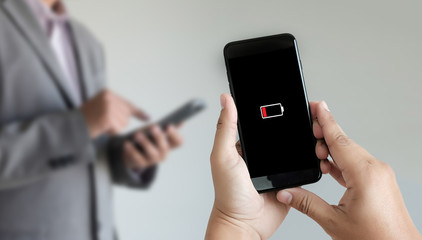 Close up man hands using smart phone battery low charged battery screen