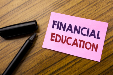 Word, writing Financial Education. Business concept for Finance Knowledge Written on sticky note red paper, wooden background with pen. Note stick on the desk.