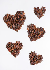 Hearts made of roasted coffee beans on white background