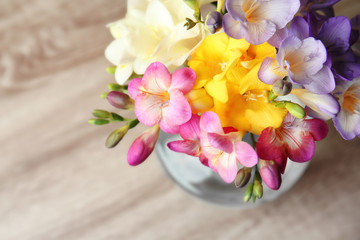 Beautiful bouquet of freesia flowers on table