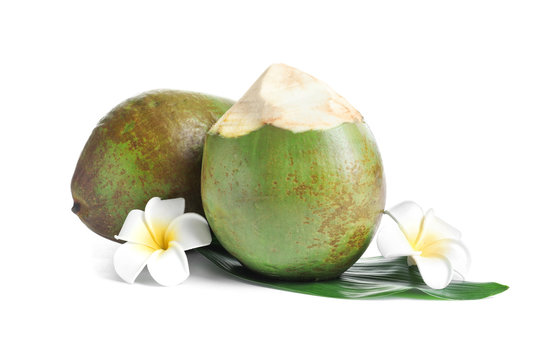Fresh green coconuts with flowers on white background