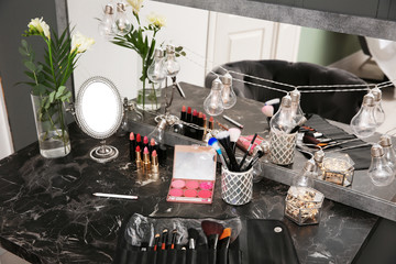 Decorative cosmetics and tools on dressing table in makeup room