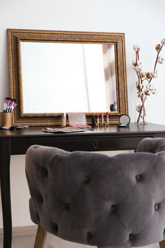 Dressing table with mirror and cosmetics in makeup room