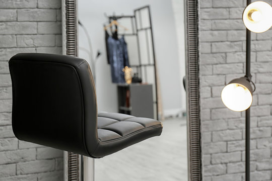 Comfortable chair near mirror in makeup room