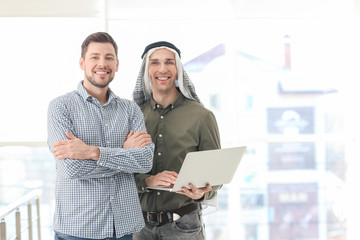 Muslim businessman with coworker in office